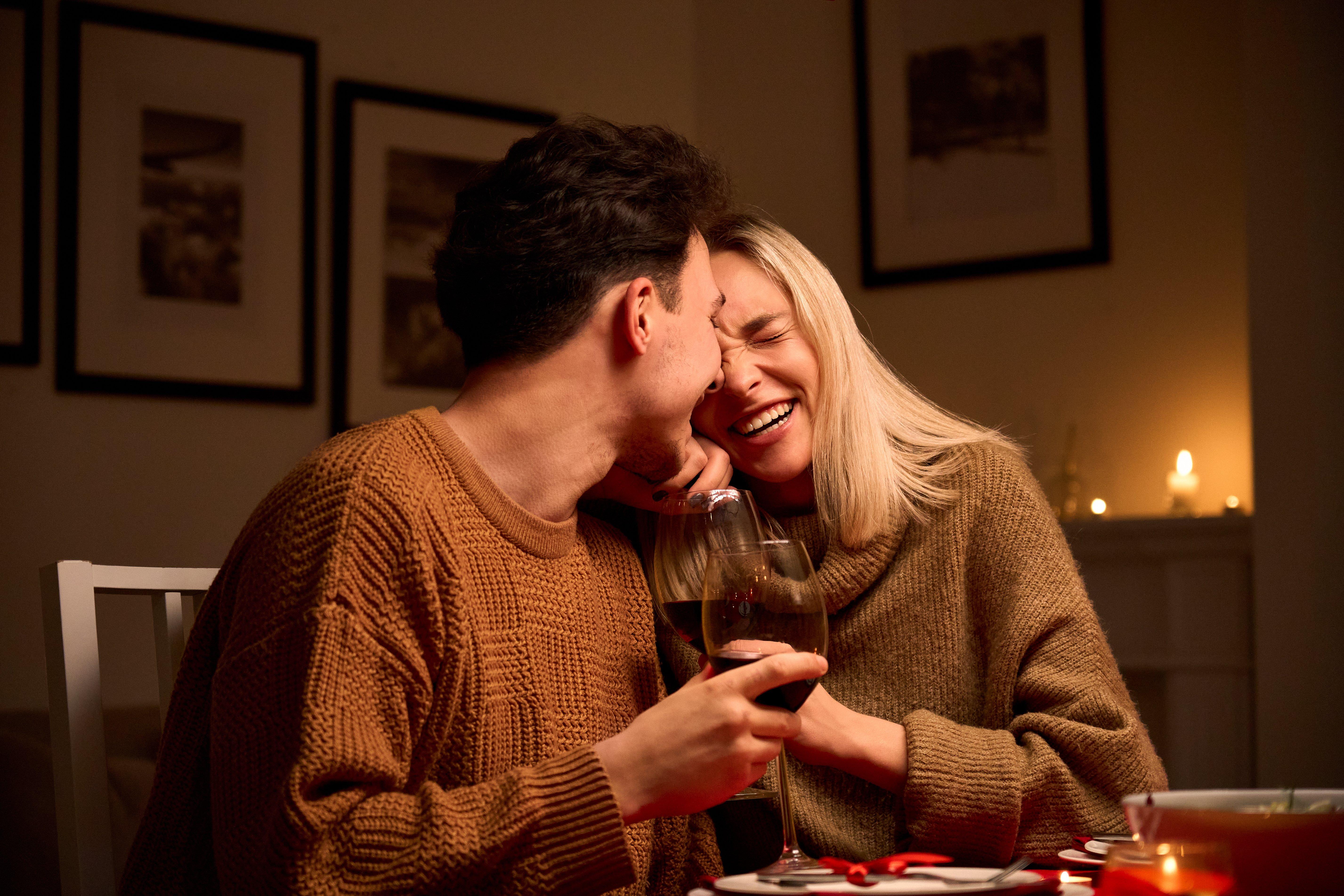 Man_and_woman_laughing_and_holding_glasses_of_wine